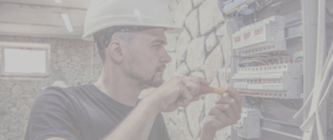 Fond d'écran grisé d'un artisan électricien travaillant sur un tableau électrique